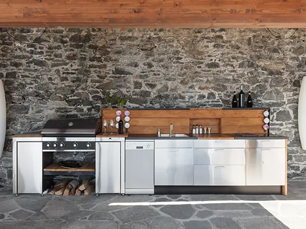 An outdoor kitchen with flagstone patio and brick walls