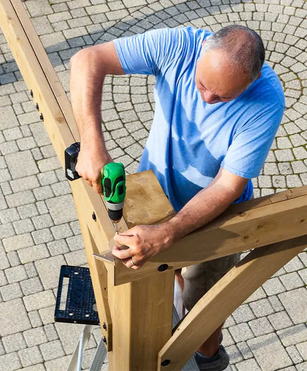 Man Installing A Pergola Frame In Texas