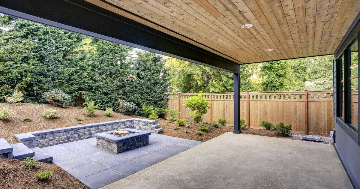 Backyard patio with fire pit under wood-paneled ceiling