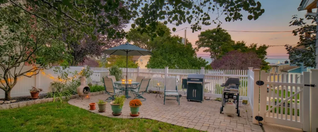Backyard patio setup with umbrella, seating, and decorative plants