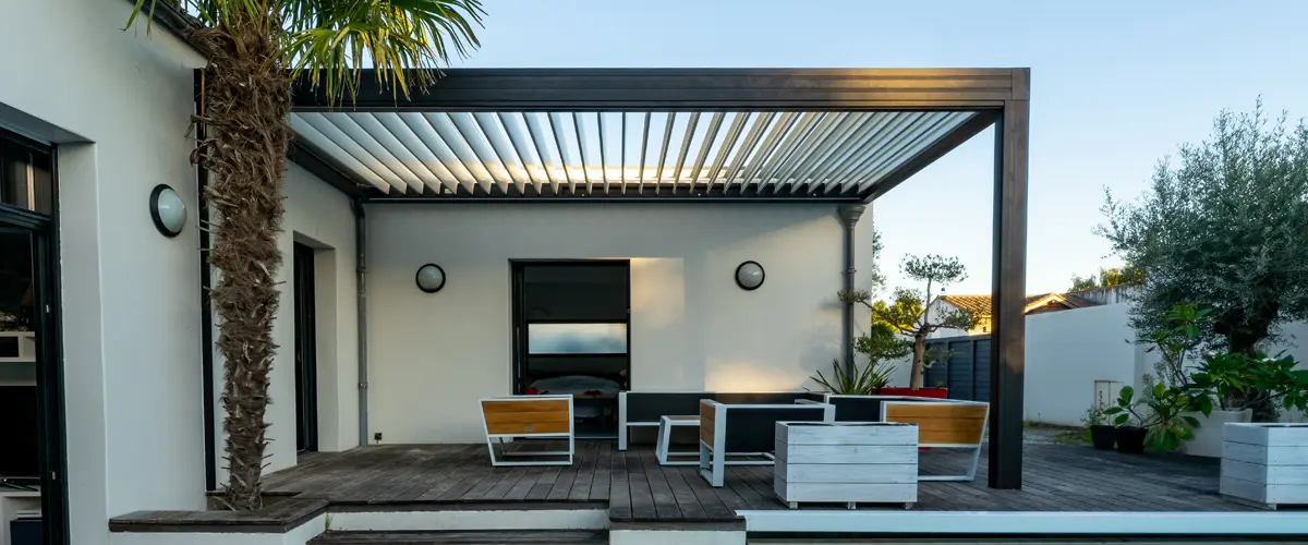 Dark metal pergola over patio with lounge furniture