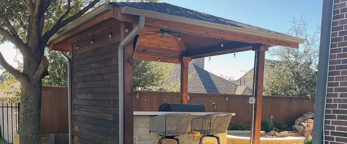 Covered outdoor bar with wood siding and stools