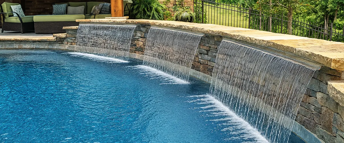 Stone poolside waterfall feature with lounge area