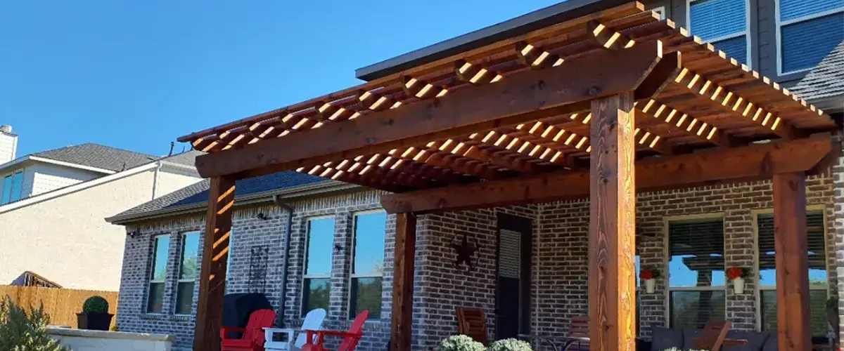 Wooden pergola attached to brick house with outdoor seating