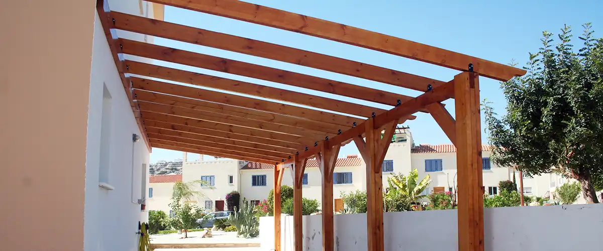Long wooden pergola providing shade along a house side walkway