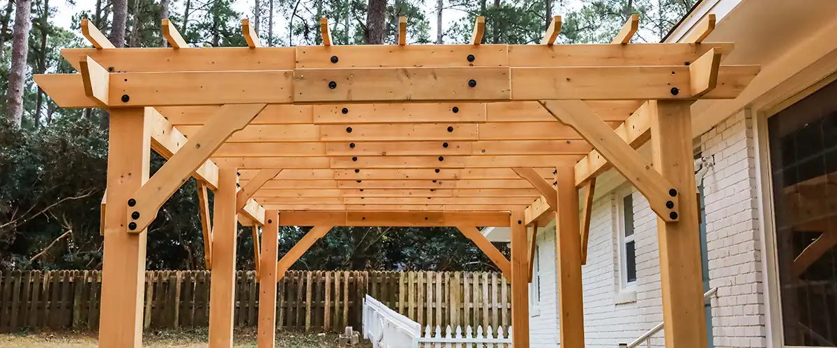 Wooden pergola attached to a house exterior wall