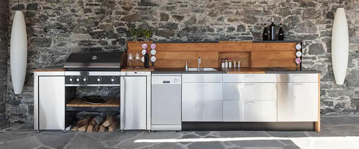 Modern outdoor kitchen featuring stainless steel cabinets and grill