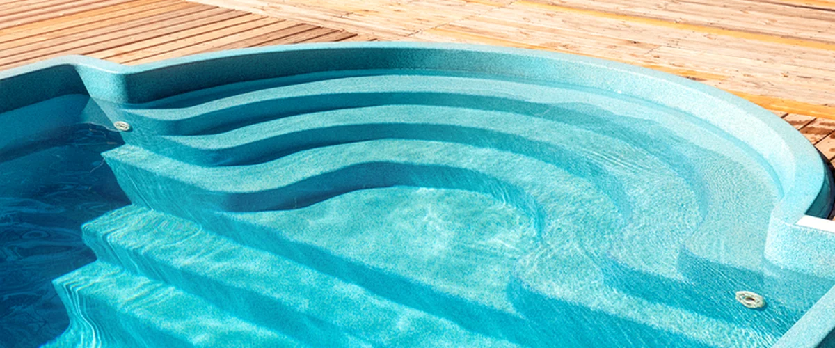 pool builder frisco tx pool spa installation crystal clear blue pool with curved steps surrounded by wooden deck