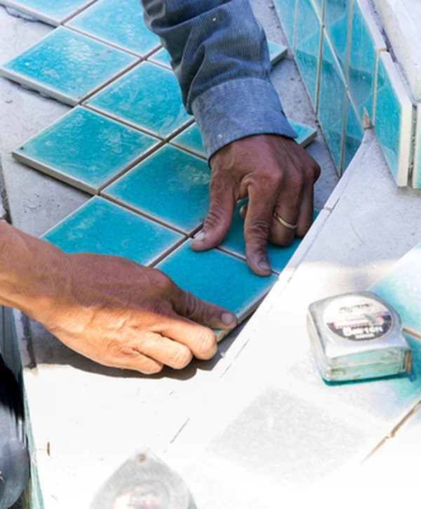 pool builder frisco tx pool spa installation professional contractor installing turquoise ceramic tiles on swimming pool steps