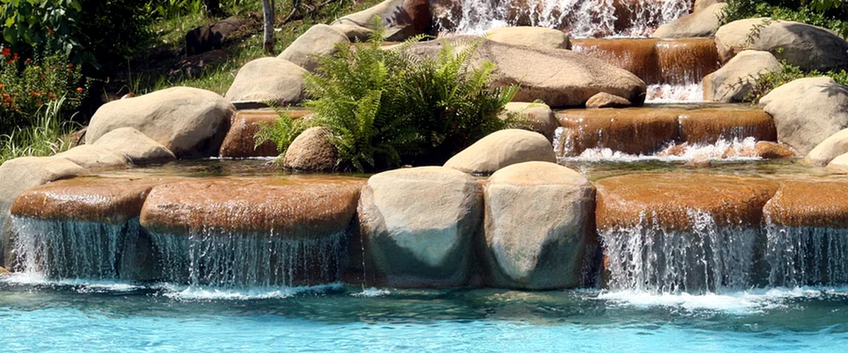 pool builders mckinney tx pool spa installation professional grade stone waterfall cascading into clear blue swimming pool