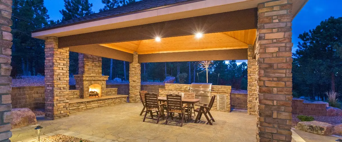Covered patio featuring a cozy fireplace and a fully equipped outdoor kitchen