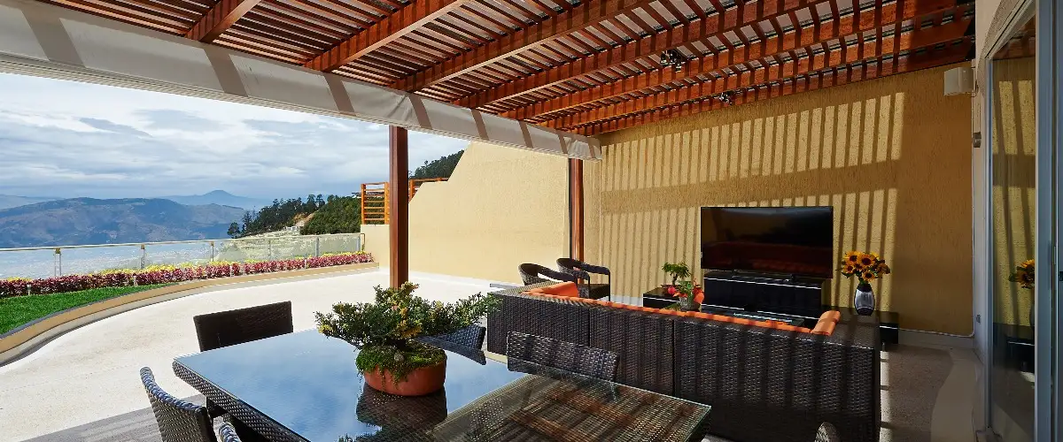 Covered patio with furniture overlooking scenic mountains in the background.