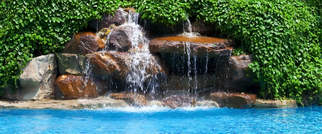 pool-spa-installation-texas-luxurious-pool-with-cascading-rock-waterfall-surrounded-by-lush-greenery