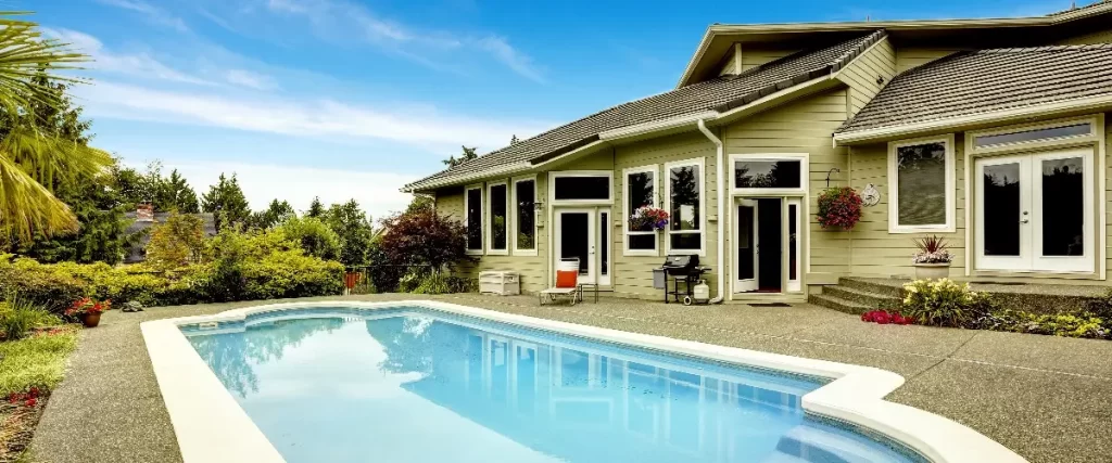 a large, luxurious, single-family home with an in-ground swimming pool in the backyard