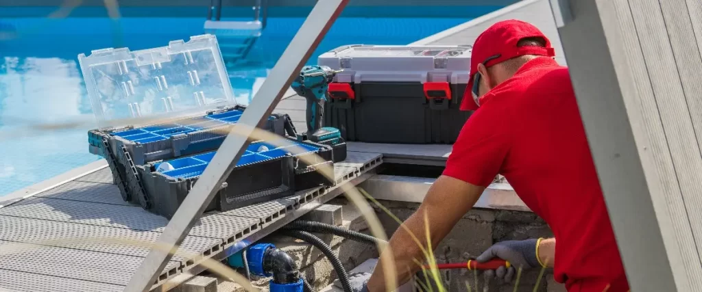 a technician performing maintenance or installation on a swimming pool pump system