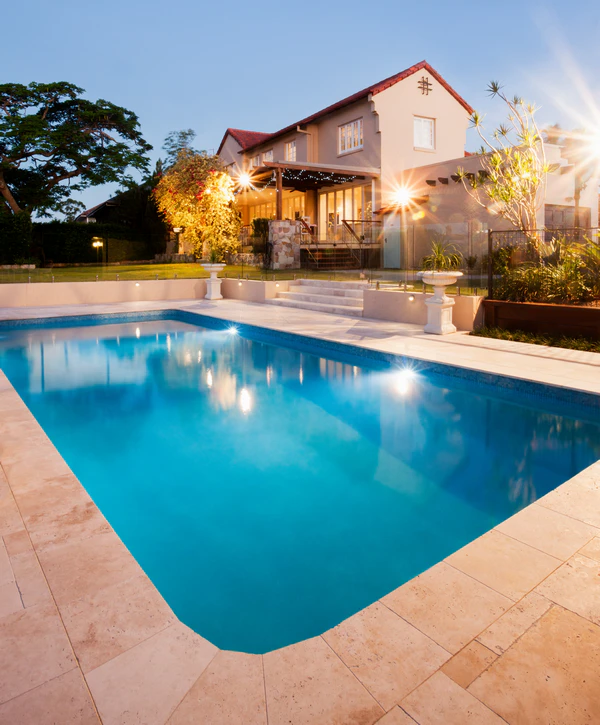 A wide-angle view of a luxury pool design featuring custom stonework and blue water in Carrollton, TX.