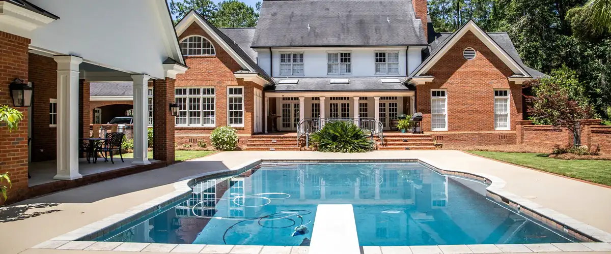 Close-up of a modern inground backyard pool featuring a custom cascading water stone element.