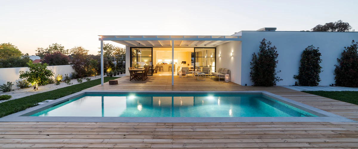 High-quality limestone coping surrounding a serene backyard pool with turquoise water.