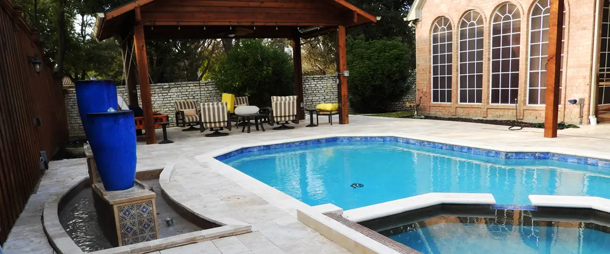 Luxury backyard pool renovation with custom spa, patio, and covered outdoor living area