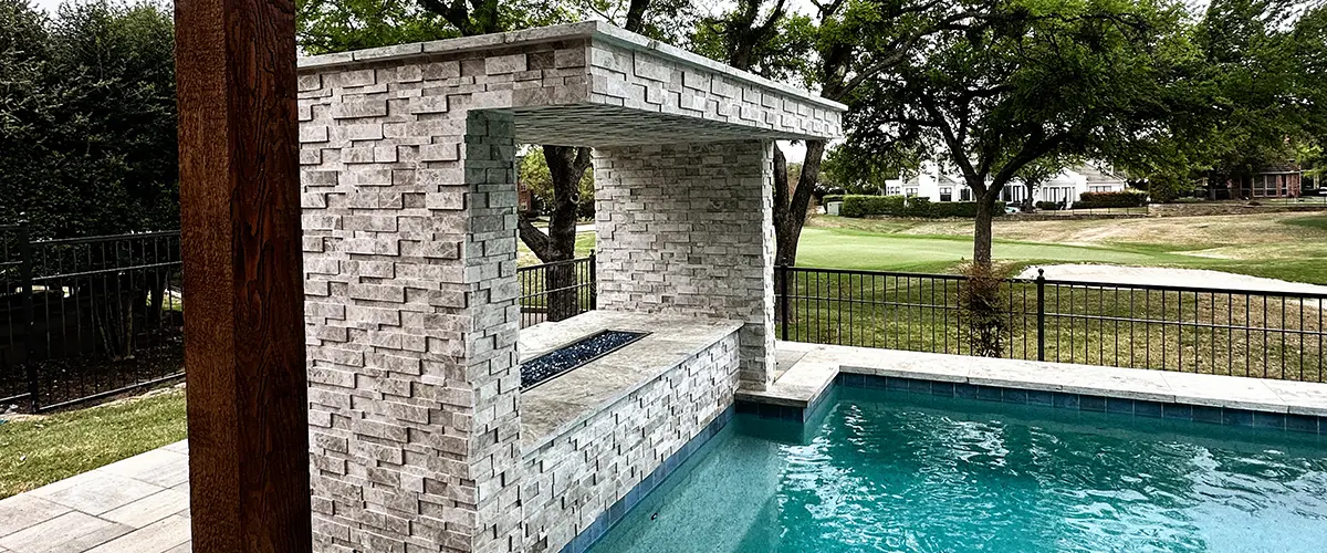 Luxury swimming pool with custom stone water feature and modern outdoor living space