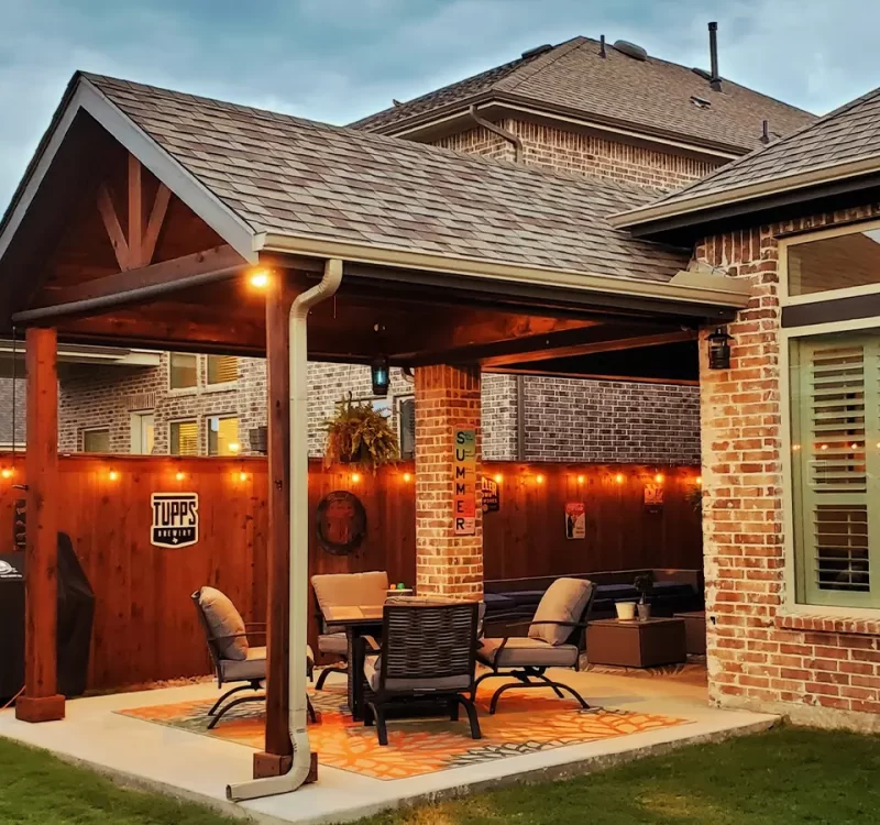 Covered patio with string lights and cozy outdoor seating area