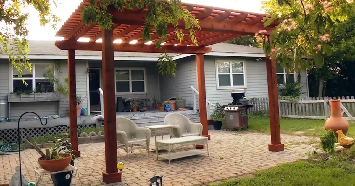 Backyard pergola with wicker furniture on a stone patio